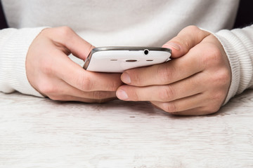 Hands holding a mobile phone and reading a text.