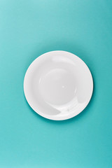 Empty plate on the turquoise background
