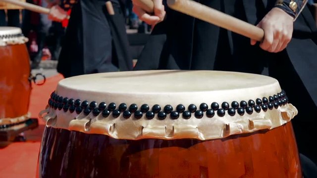 Musicians drummers play taiko drums chu-daiko outdoors. Culture folk music of Asia Korea, Japan, China.
