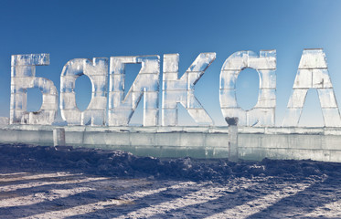Baikal Lake in winter day. Big letters made of transparent ice in word BAIKAL against the blue sky