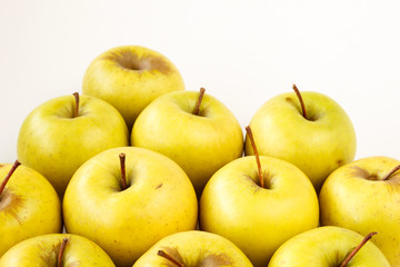 Golden delicious apples on light beige background with copy space