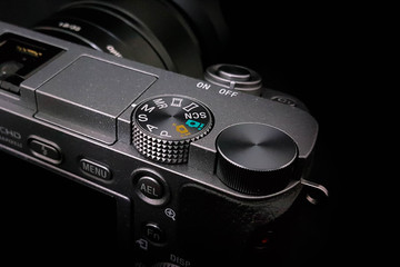 Control dial on a DSLR camera, mirrorless, close up image isolated on black background