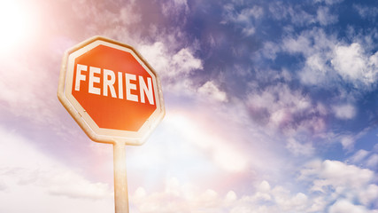 Ferien auf rotem Stoppschild vor blauem Wolkenhimmel