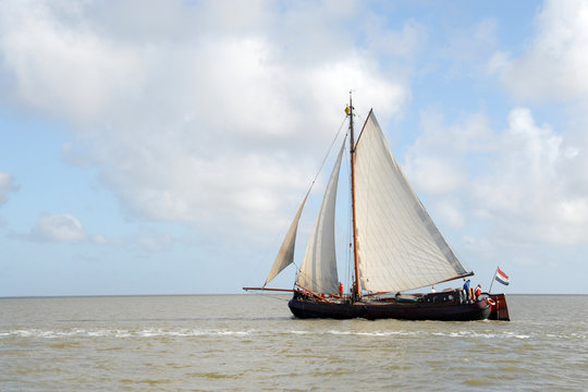 een houten zeilboot vaart op zee