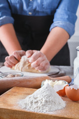 Obraz na płótnie Canvas Woman baker knead yeast dough with eggs and flour