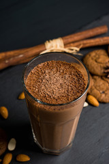 Chocolate smoothie with bananas and cookies on the dark wooden background