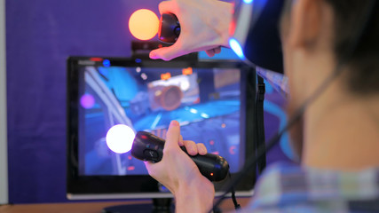 Virtual reality game. Young man using virtual reality glasses and hand controlers