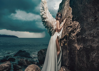 Beautiful young angel climbing on the clif