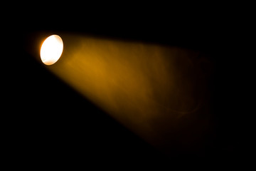 Authentic beam of light from reflector in theatre, smoke colored on yellow, orange and red colours.
