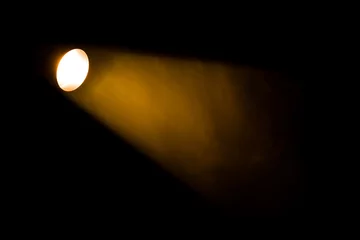 Fotobehang Licht en schaduw Authentieke lichtbundel van reflector in theater, rook gekleurd op gele, oranje en rode kleuren.