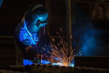 Worker is welding in factory 