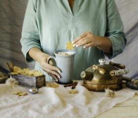 woman's hands holding a cup of cocoa over the dinner table, selective focus