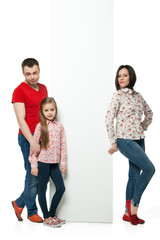 Obraz premium Happy family standing behind billboard 