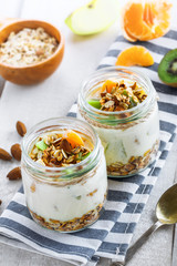 Healthy homemade granola with yogurt and fruits in a rustic jar. Traditional American food on a table. Classic snack. Top view.