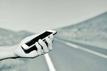 man using a smartphone next to the road