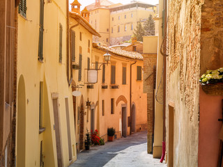Beautiful narrow alley with traditional historic houses at Pienza city