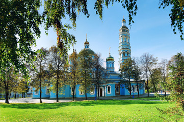 Blue Orthodox Church with a green lawn in summer