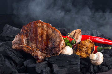 meat grilling on coal background with mushrooms, garlic and red pepper