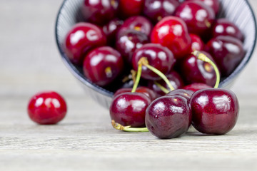 Closeup image of cherries on a wooden surface.