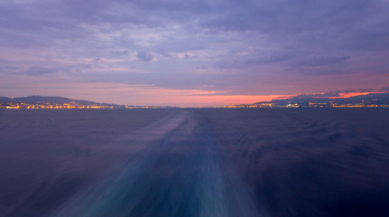 Italy's narrow and busy Strait of Messina, separating Sicily and Calabria, during a cloudy sunrise
