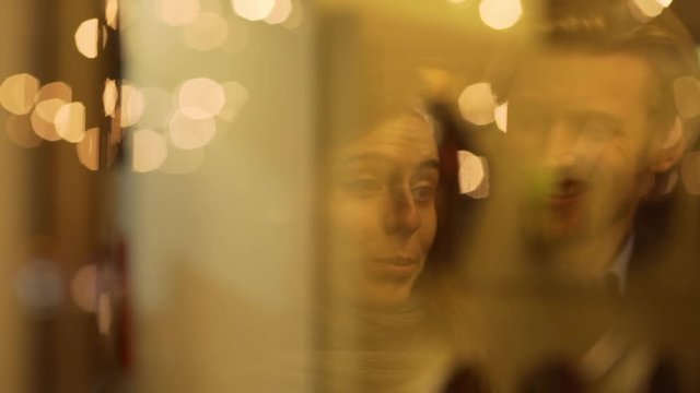 Young beautiful Caucasian pair of lovers smiling talking out-of-focus in yellow reflection in slowmotion