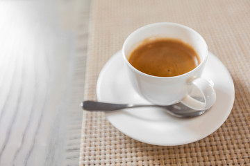 hot coffee in white cup on vintage wooden table