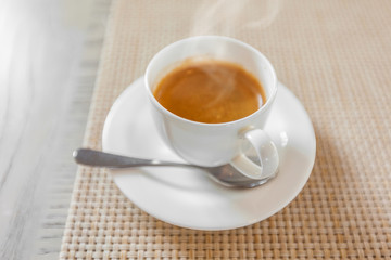 hot coffee in white cup on vintage wooden table