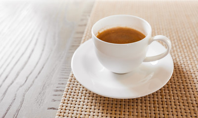 hot coffee in white cup on vintage wooden table
