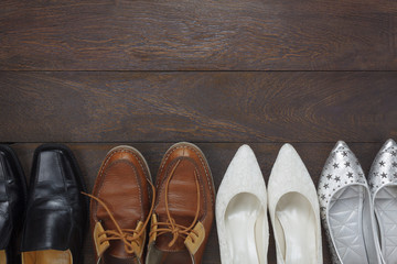Top view  fashionable several design of men and women shoes on wooden floor with copy space.