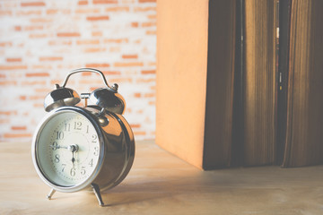 Retro alarm clock with row book on wood table