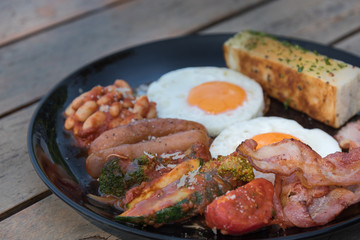 Breakfast in black plate on wooden table
