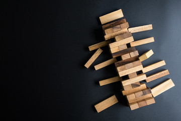 Close up blocks wood game (jenga) on black background with copy space for your text.