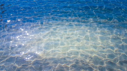 blue water wave with shining white twinkling from the sun