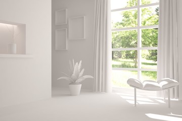 Fototapeta na wymiar White room with chair and green landscape in window. Scandinavian interior design