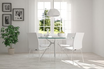 White dinner room with green landscape in window. Scandinavian interior design