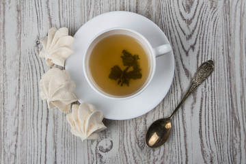 A cup of tea with three biscuits