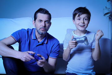Vater und Sohn spielen mit der Spielkonsole Computer- oder Videospiele 