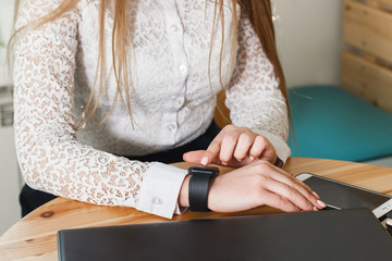 Close up young woman using her modern smart watch