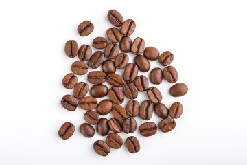 Naklejka premium roasted coffee beans isolated in white background. Roasted coffee beans background close up. Coffee beans pile from top on white background with copy space for text. Good morning.