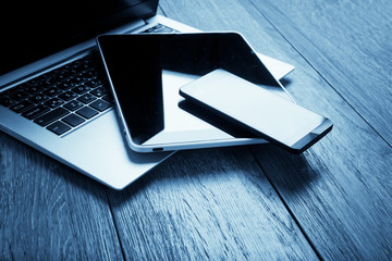 keyboard with phone and tablet pc on wooden desk