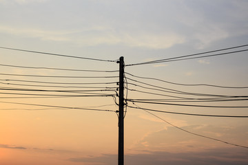 Silhouette of Electric pole power lines and wires in the evening time.