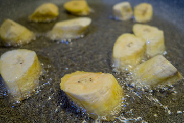 Pezzi di banana sbucciata che cuociono nell’olio d’oliva