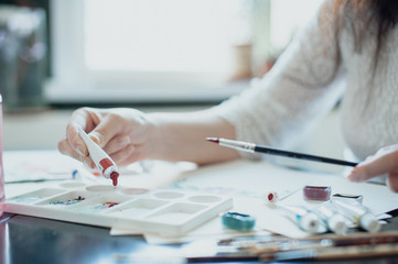 girl painter in white dress draws paints