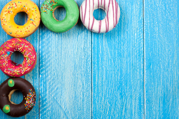 glazed donuts on a blue wooden background with copy space for your text. Top view