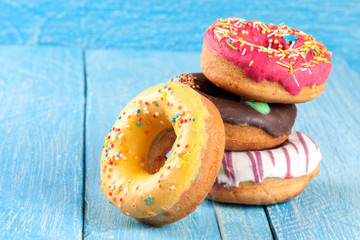 pile of glazed donuts on a blue wooden background