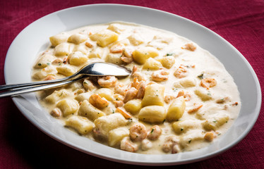 Pasta with cream sauce and seafood in white plate