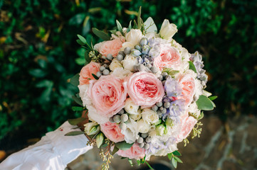 Beautifully decorated bouquet closeup with white and pink roses, sky flowers