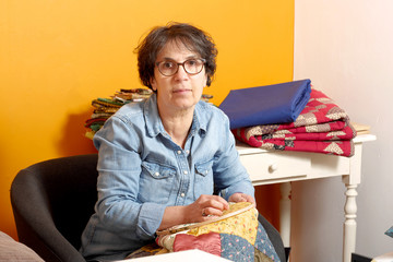 woman sewing for finish a quilt.