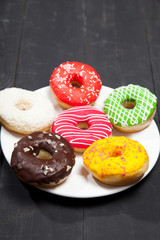 Colorful donuts on a black table