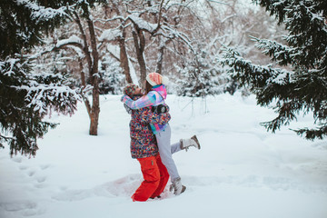 happy couple embrace and love in the winter forest